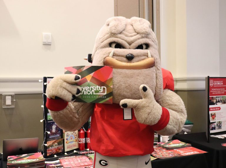 UGA mascot posing with a Student Union flyer