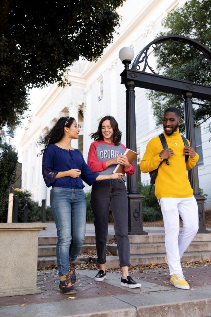 Students walking near UGA arch.